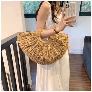 Detail of hand-woven straw handbag showing natural fiber texture and round cutout handle