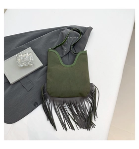 Detail of army green suede shoulder bag with long fringes in bohemian retro style