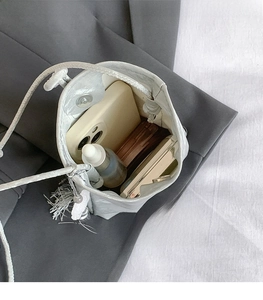 Silver metallic bucket bag interior showing capacity with pearl and tassel charms
