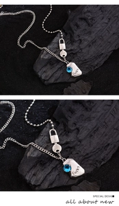 Macro shot of Lucky blue zircon pendant and vintage silver link chain on dark texture