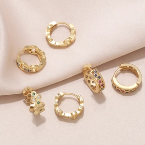 Lot de six créoles huggie plaquées or avec zircons colorés sur fond de soie rose