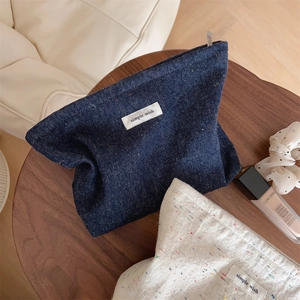 Flat lay of vintage denim and beige makeup bags with Simple Wish tags on a wooden table