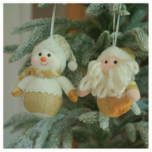 Detail view of handmade snowman and Santa Claus fabric ornaments hanging on a Christmas tree