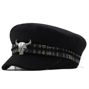 Minimalist black military cap with ethnic woven band and silver bull skull ornament