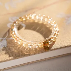 Golden rutilated quartz and clear crystal beaded bracelet with metallic coin charm