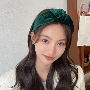 Deep green velvet knotted wide headband shown on a model for an elegant winter look