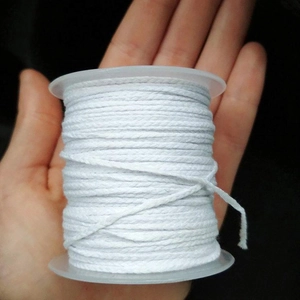 Close-up of 61m braided cotton candle wick on spool held in hand for scale