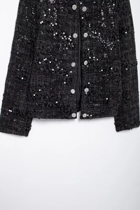 Detailansicht der schwarzen Pailletten-Tweedjacke mit silbernen Blumenknöpfen und Saumstruktur