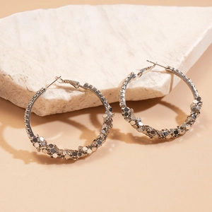 Silver geometric hoop earrings with sparkling sequins on marble background
