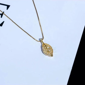 Makroansicht des goldenen Blattanhängers mit Kristalleinlage und Blattadern