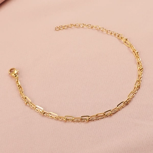 Detailed view of golden double-layer bracelet with paperclip and beaded chain links