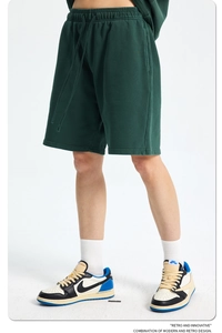 Detail of dark green cotton gym shorts showing elastic waistband and drawstring texture