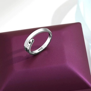 Detail of S925 sterling silver ring with heart engraving on a purple velvet stand