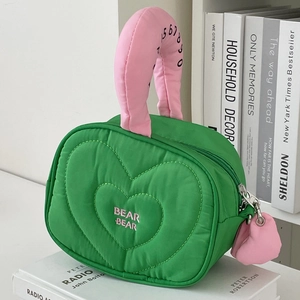 Dettaglio della borsa trapuntata a cuore verde e rosa con ricamo rosa BEAR BEAR e ciondolo