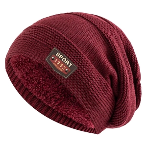 Detail view of burgundy knit hat featuring thick warm fleece lining and leather sport patch