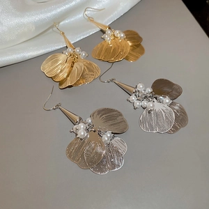 Detailed view of layered petal earrings with pearls in gold and silver finishes