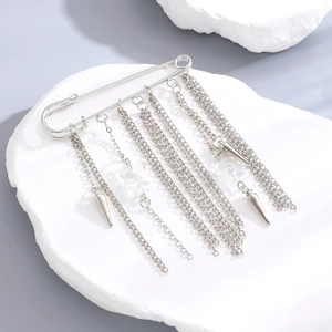 Detail of silver chain brooch with metal spikes and transparent beads on white stone