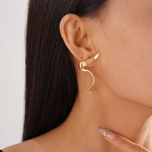 Close-up of a minimalist golden spiral earring showing modern geometric polished metal design