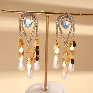 Vue détaillée des boucles d'oreilles plaquées or 18k avec strass en poire et perles blanches