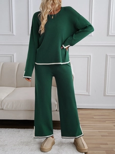 Close-up of dark green knitted two-piece set featuring white stripe trim on sleeves and hem