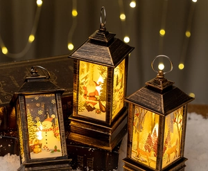 Close-up of vintage bronze LED Christmas lanterns with snowman and Santa motifs on books