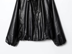 Details von Saum, Manschetten und Metallreißverschluss dieser schwarzen Kunstlederjacke