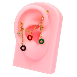 Close-up of gold industrial barbell chain with colorful drip charms and clear rhinestones