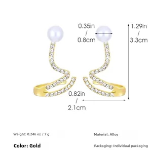 Détail de boucles d'oreilles dorées en S avec perles blanches, strass et dimensions