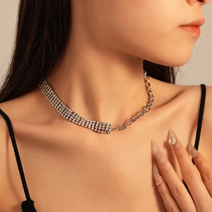Close-up of luxury rhinestone choker with silver metal chain stitching and mixed textures