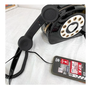Close-up of creative retro phone crossbody bag in black patent leather with dial detail