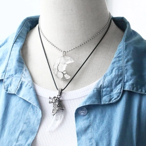 Detail of moon wire-wrapped clear quartz and wolf head crystal pendant layered necklaces