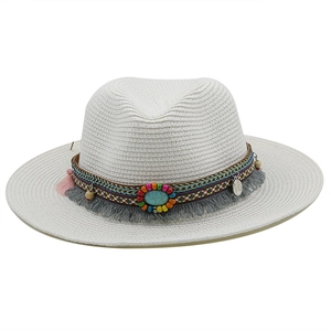 Detail of white straw fedora featuring a bohemian colorful band and turquoise bead