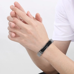 Detail of silver stainless steel mesh bracelet with a black crystal centerpiece on wrist