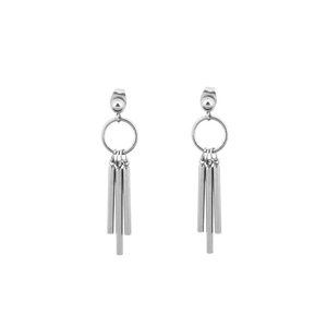 Detailed macro view of silver titanium steel earrings with hanging cylindrical tassels