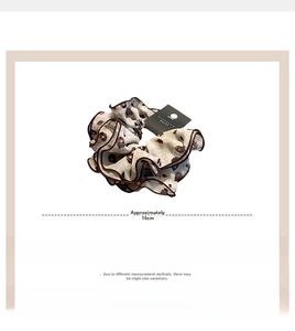 Detailed view of a 16cm floral chiffon scrunchie with delicate brown overlock edges