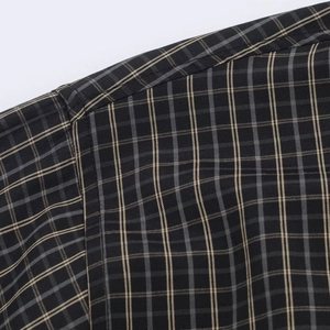 Macro view of woven plaid shirt fabric texture and professional stitching craftsmanship