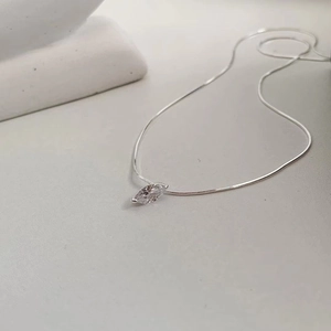 Macro shot of 925 silver marquise-cut clear zircon pendant on fine snake chain
