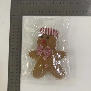 Detail view of plush gingerbread man with ruler measuring dimensions about 16cm tall