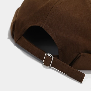 Detail of dark brown cotton beanie with adjustable silver metal buckle and strap