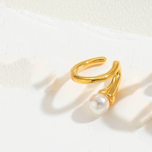 Detail of a minimalist gold U-shaped ear cuff with a single white round pearl on stone