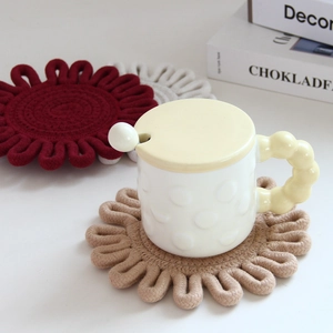 Detail of flower-shaped woven cotton coasters in beige, red, and white for home decor