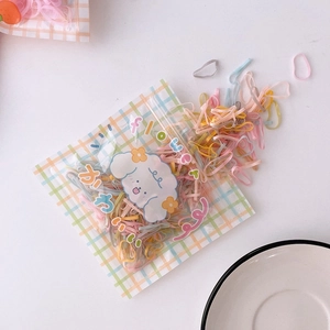 Detail of colorful elastic hair bands in a cute illustrated pouch on white background