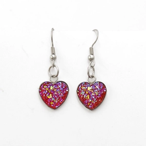 Detail of heart-shaped earrings with red glitter finish and stainless steel hooks