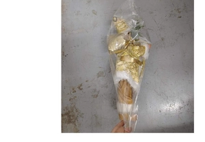 Standing Santa Claus doll in gold and white suit wrapped in protective packaging