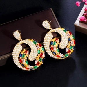 Détail de créoles dorées avec zircons multicolores sur un écrin à bijoux en cuir brun