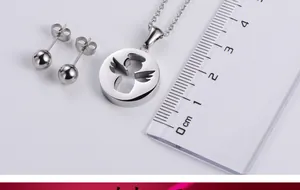 Dettaglio del set di gioielli in acciaio con pendente angelo da 20mm e orecchini a sfera