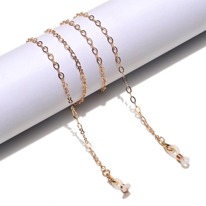 Detail of gold metal eyewear chain with white silicone loops on white pedestal