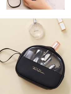 Macro view of portable black travel toiletry bag with transparent window and gold logo