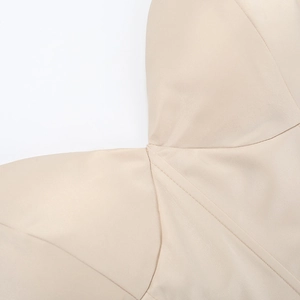 Détail de la couture d'épaule et de l'encolure sur cette robe de vacances de couleur abricot