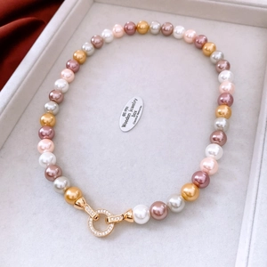 Close-up of multicolored pearls with 18K gold rhinestone encrusted round clasp jewelry